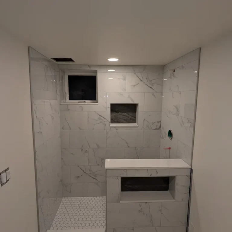 Walk-in shower with marble-look tile and built-in niche